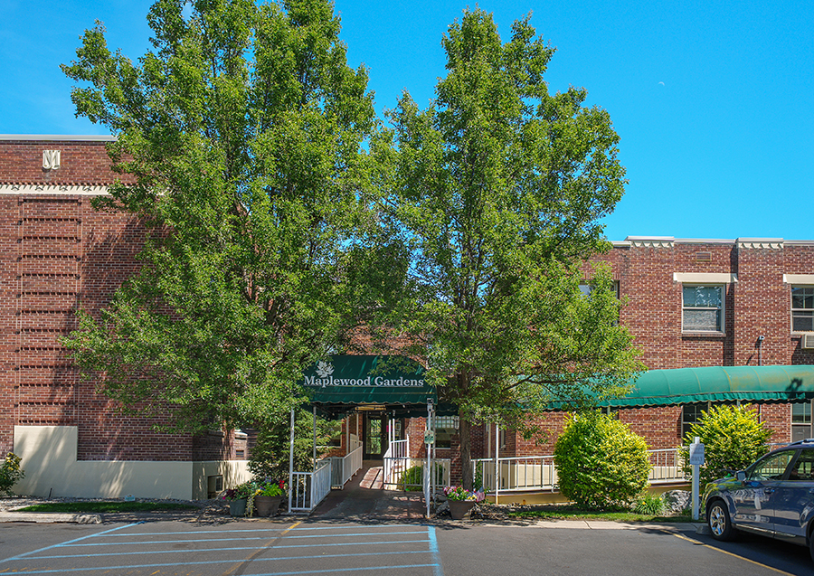 Brick building with greenery and entrance sign.
