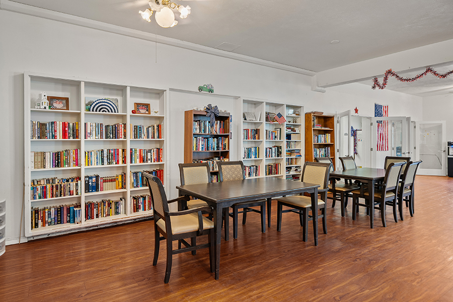 Cozy library with bookshelves and dining tables.