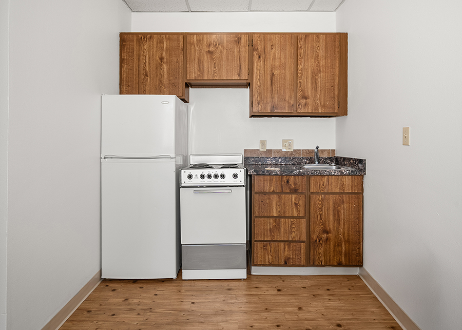 Compact kitchen with appliances and wooden cabinets.