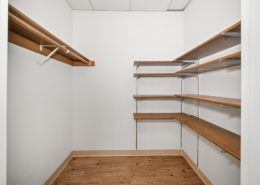 Empty closet with shelves and a hanging rod.