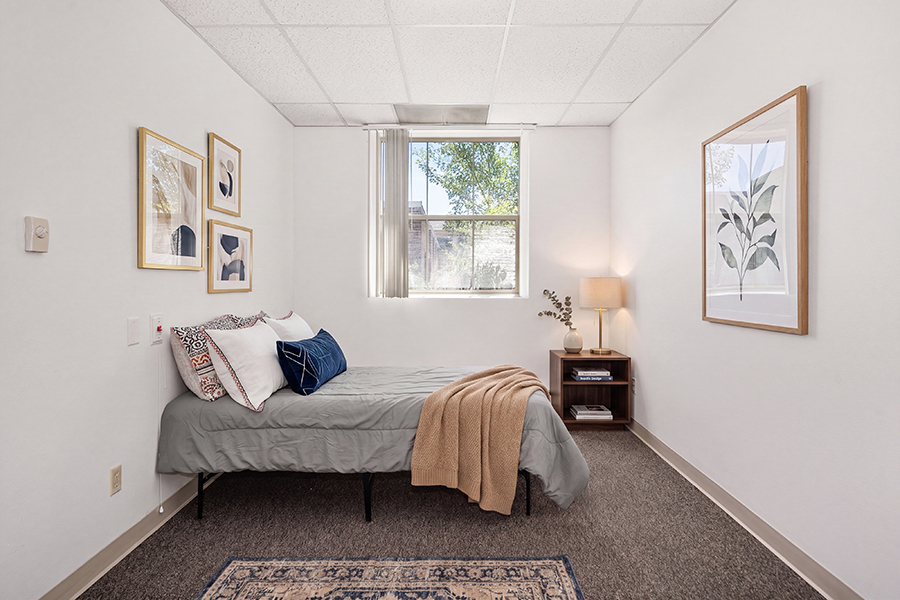 Cozy, minimalistic bedroom with a bed and decor.