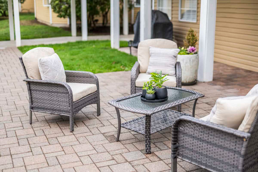 Outdoor seating area with wicker furniture and potted plants.