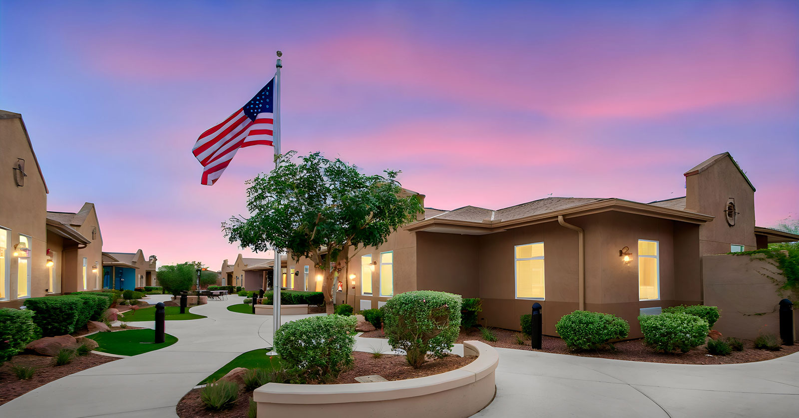 Residential area with a flag and colorful sunset sky.