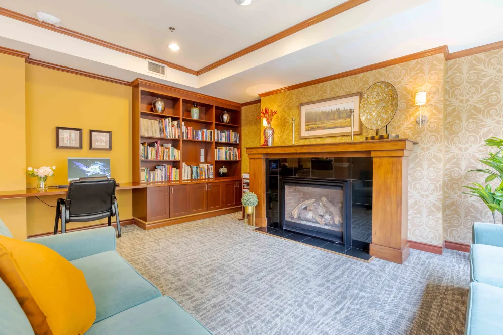 Cozy living room with bookshelf, fireplace, and comfortable seating.