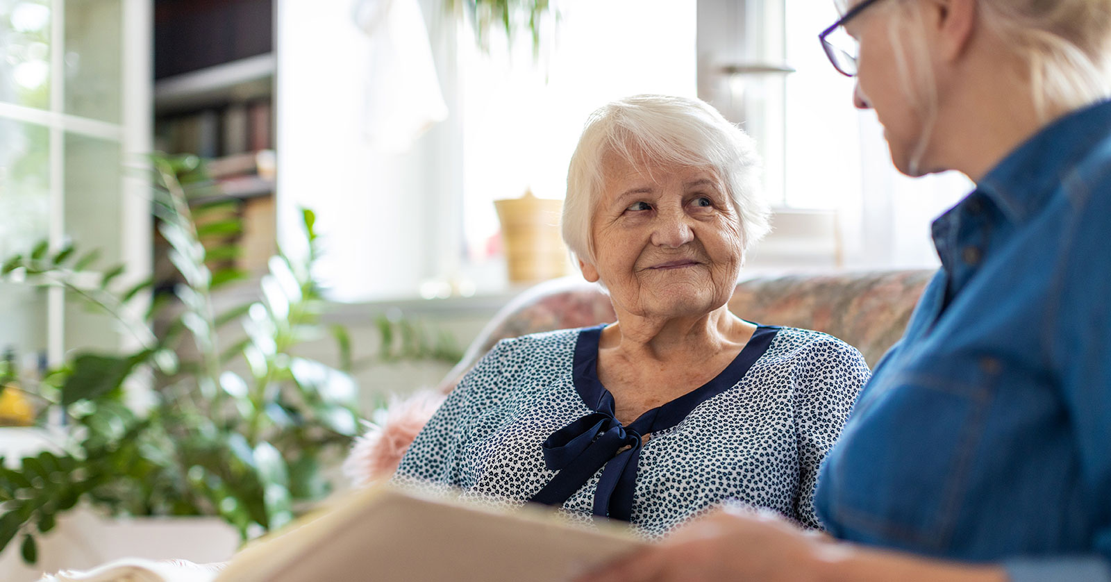 Two women engaged in a warm conversation at home.