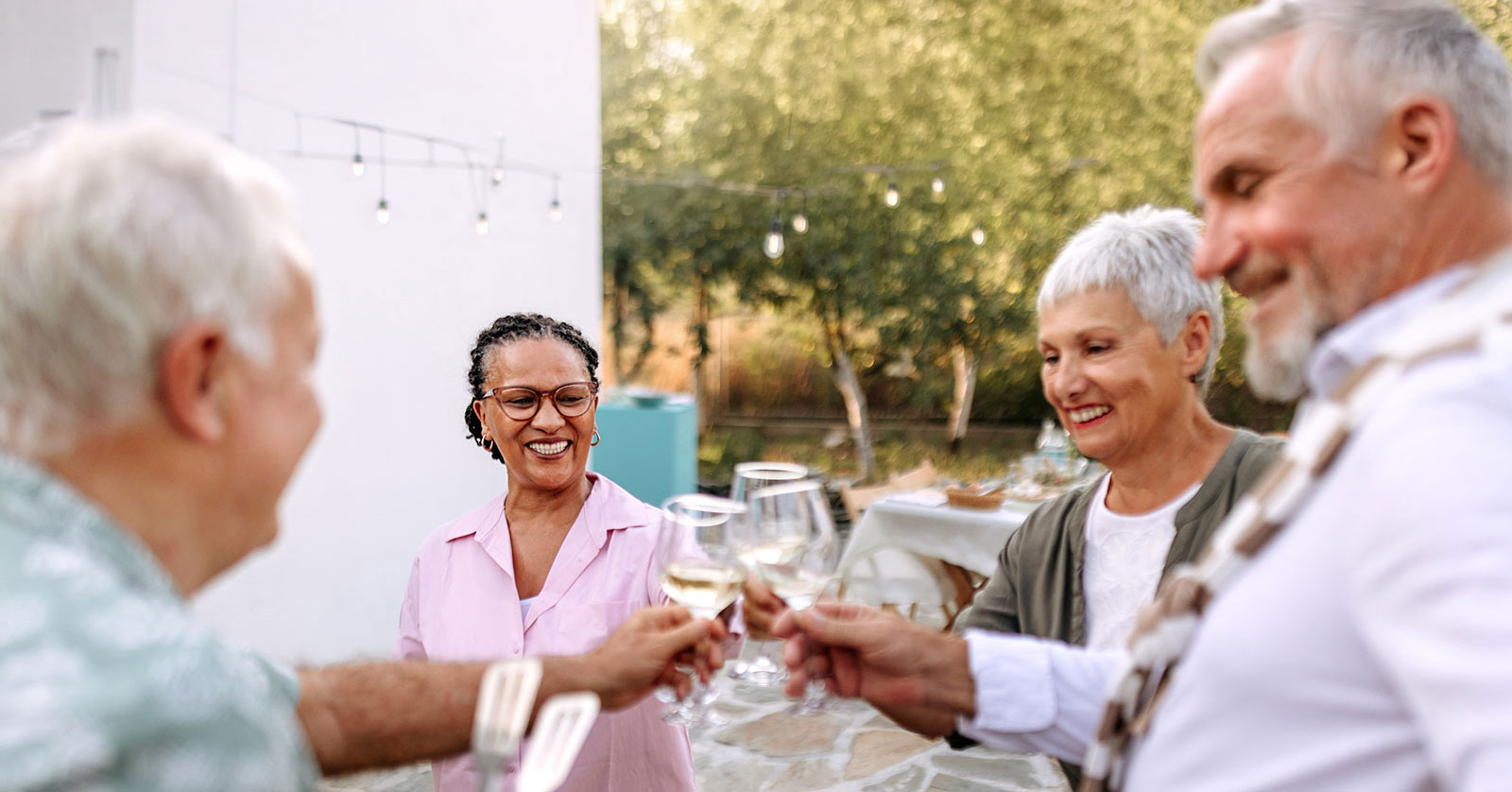 People toasting together at a festive outdoor gathering.