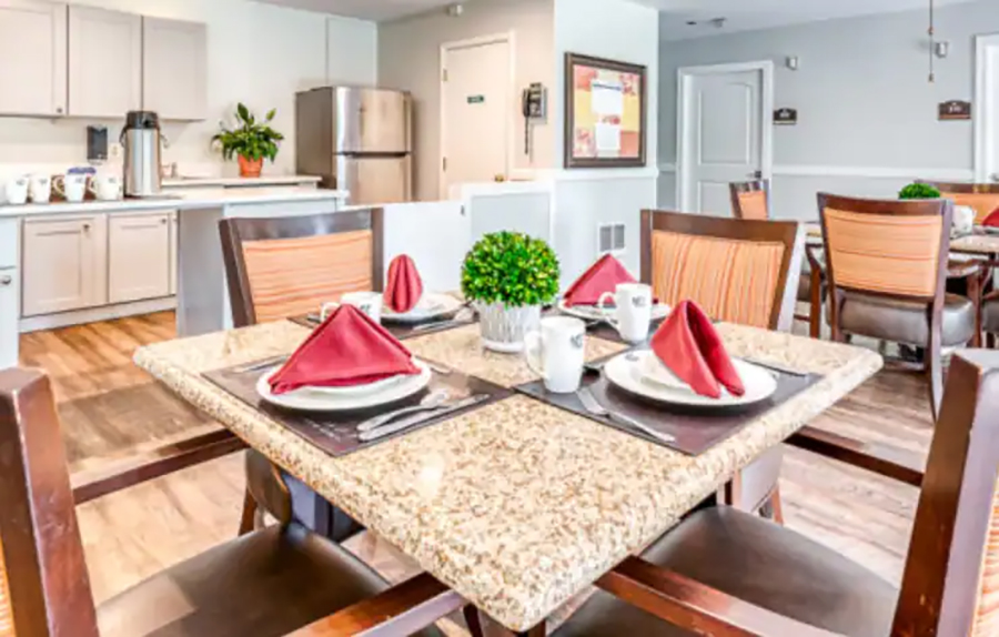 Cozy dining area with elegantly set tables and kitchenette.