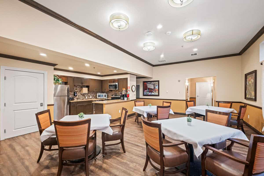 Modern dining area with tables and kitchenette visible.