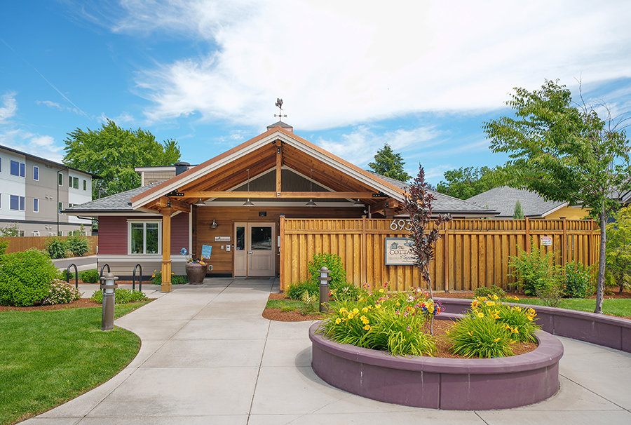 Charming building with garden, welcoming atmosphere, and blue skies.