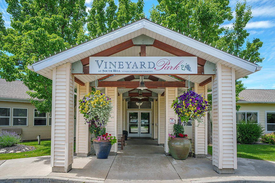 Entrance of Vineyard Park with vibrant flowers and greenery.