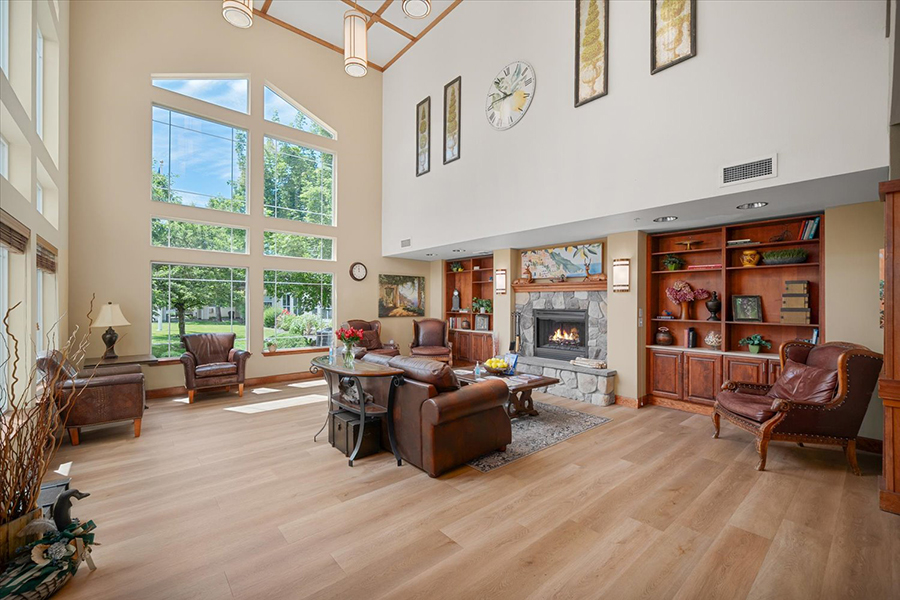 Spacious living room with large windows and cozy seating.