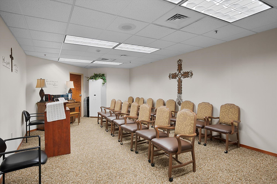 Waiting room with chairs, cross, and decor elements.