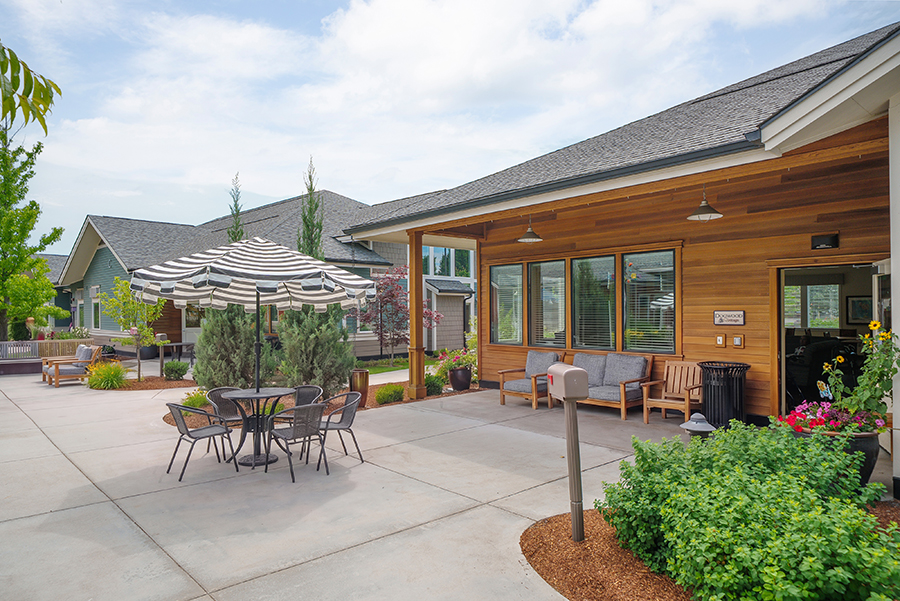 Outdoor seating area with patio umbrella and landscaped surroundings.