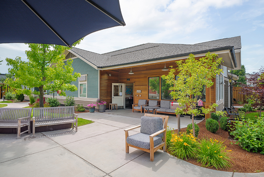 Modern building with seating and greenery in a tranquil setting.