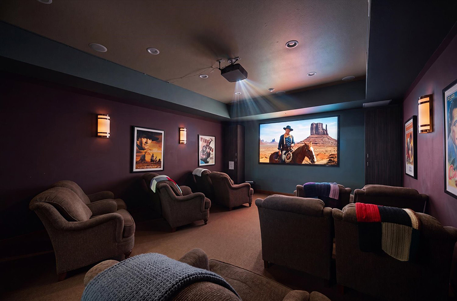 Cozy home theater with cowboy movie on projection screen.