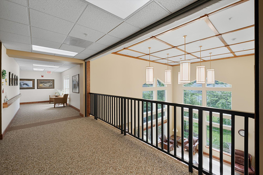 Bright hallway with seating area and large windows.
