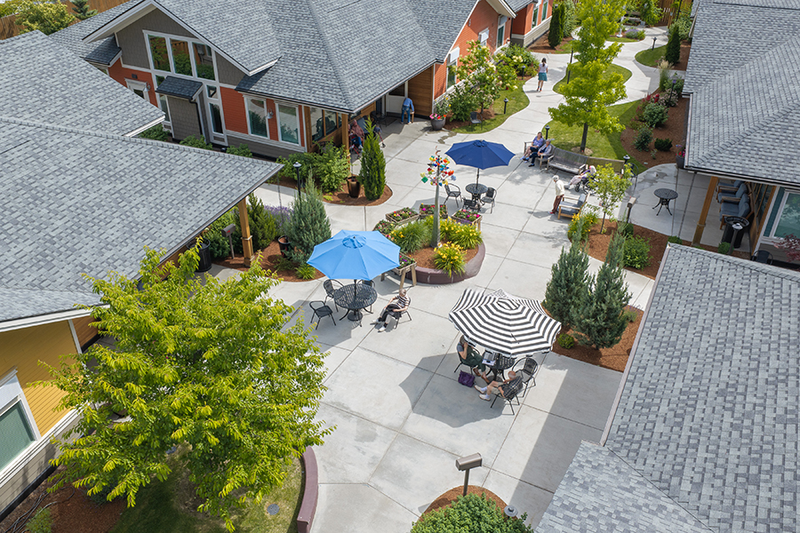 Community courtyard with seating, gardens, and vibrant colors.