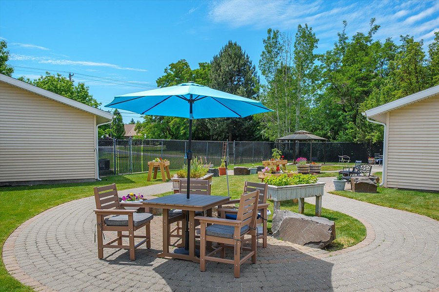 Outdoor seating area with an umbrella and garden.
