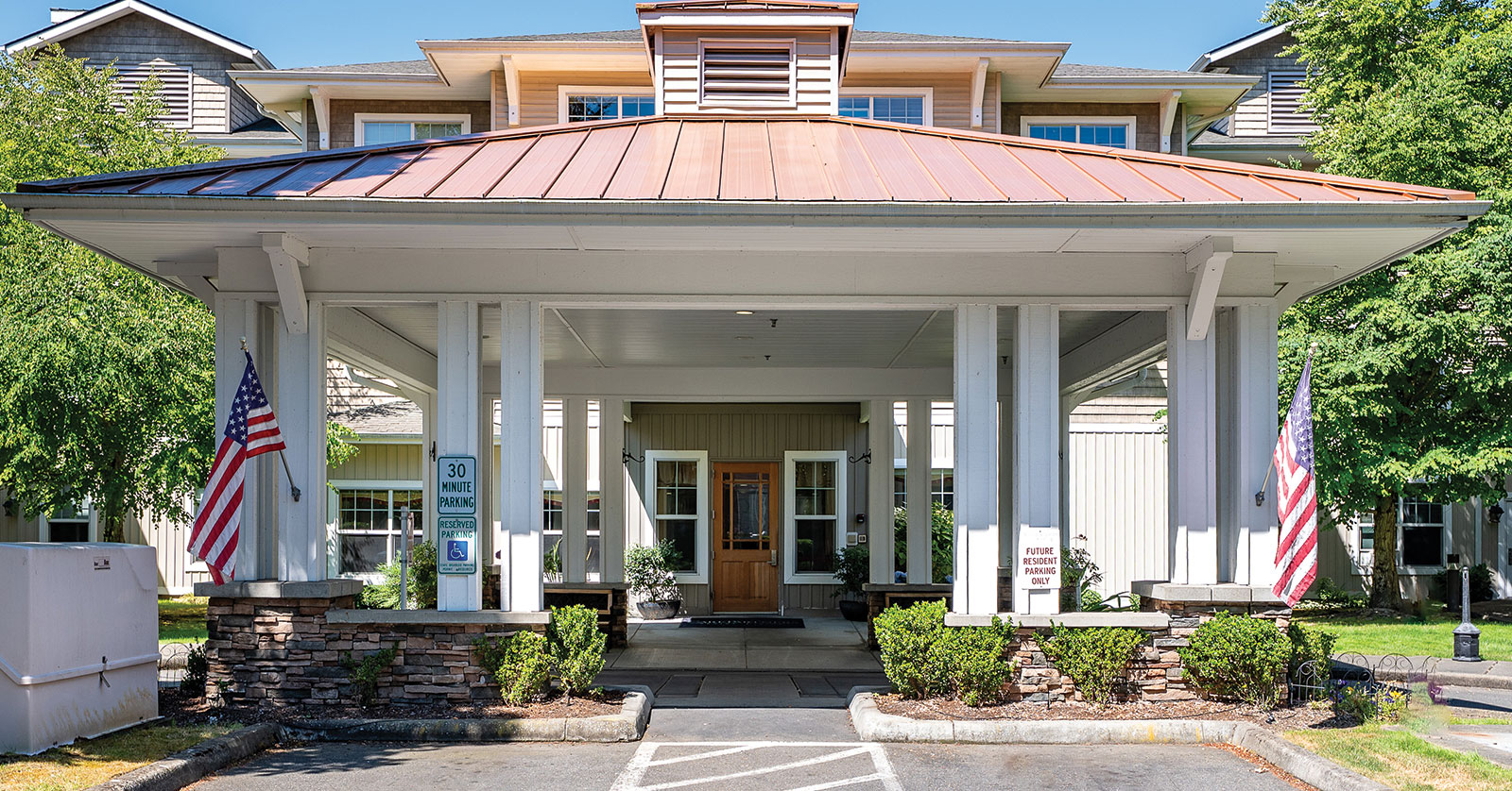 Welcoming entrance of a residential building with flags.