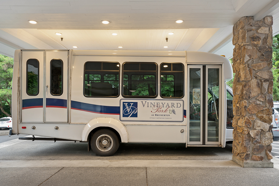 White bus with "Vineyard" branding parked under a building.