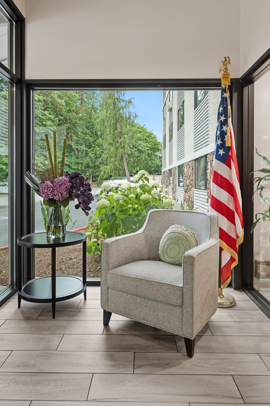 Cozy seating area with flowers and a flag.