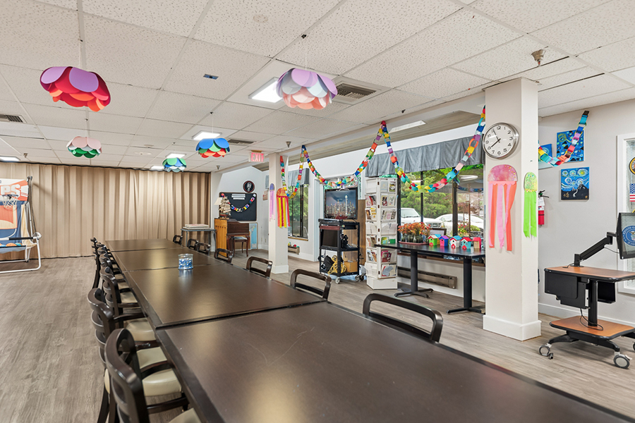 Bright, decorated room with tables and colorful hanging lights.