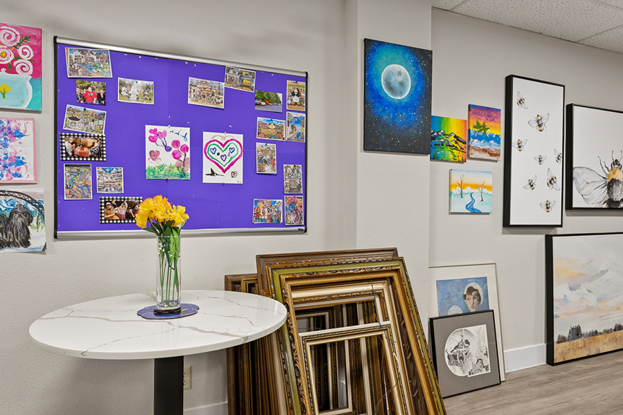 Art display with framed pictures and colorful bulletin board.