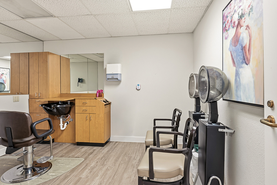 Hair salon interior with styling stations and art on walls.