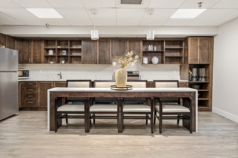 Modern kitchen with wooden cabinets and dining table centerpiece.