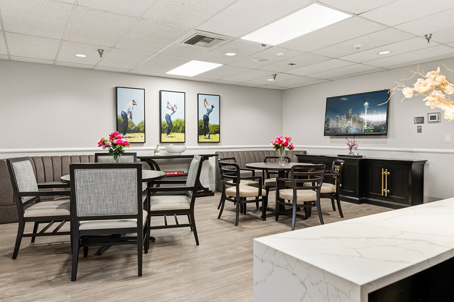 Modern lounge with dining area and golf artwork.