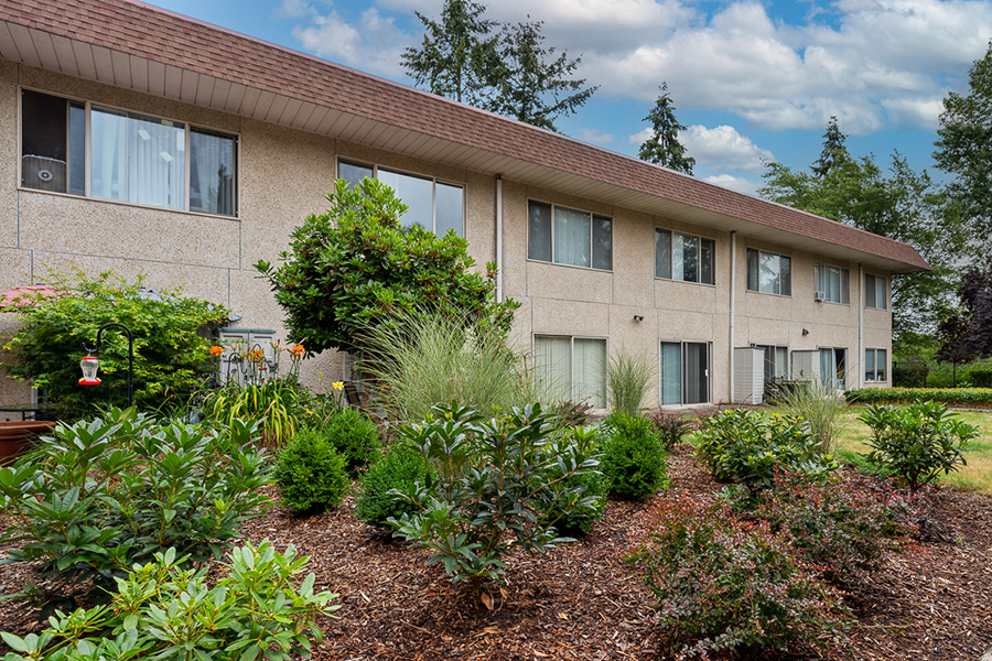 Multi-story building surrounded by landscaped gardens.
