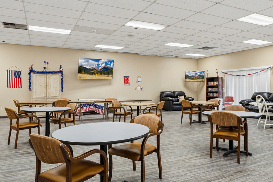 Community room with chairs, tables, and patriotic decor.