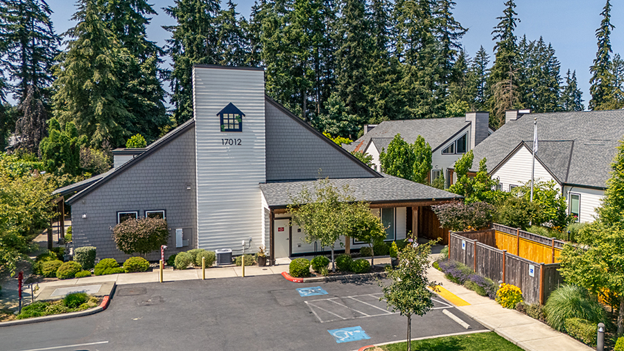 Modern building surrounded by trees and landscaped area.