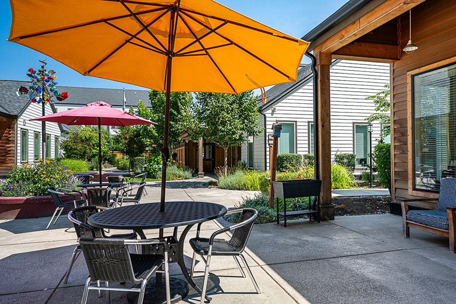 Outdoor seating area with colorful umbrellas and greenery.