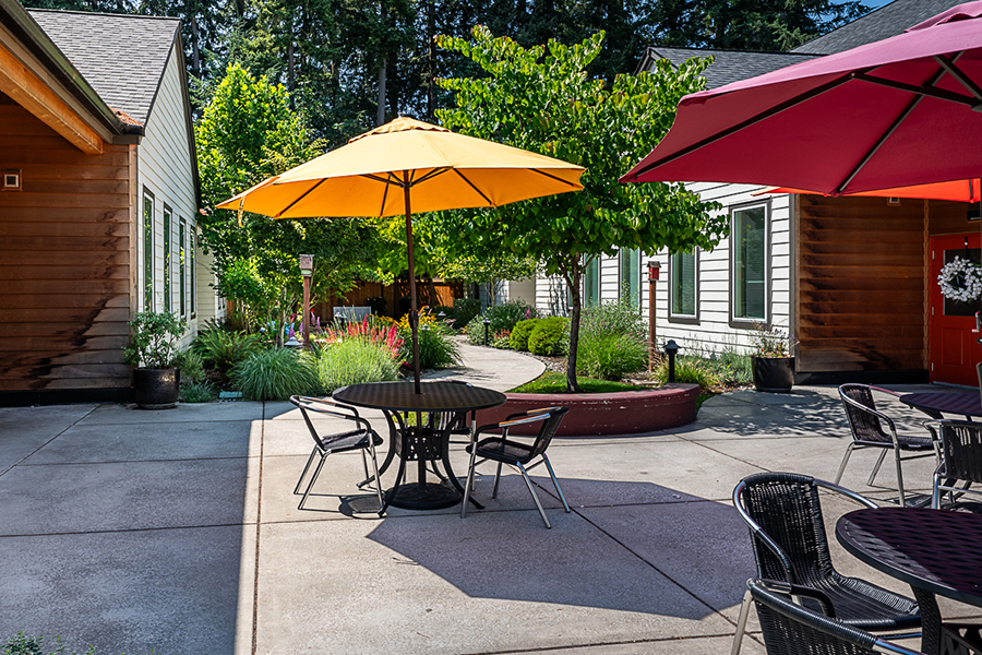 Outdoor seating area with colorful umbrellas and greenery.