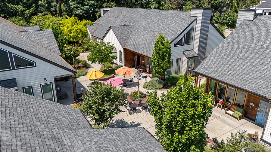 Modern buildings surrounding a vibrant courtyard with seating.
