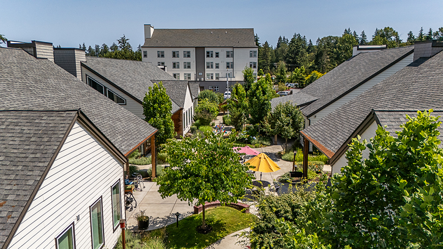 Residential complex with gardens and nearby buildings.