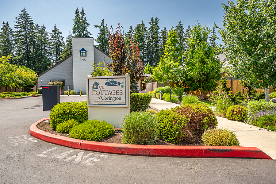 Cottages entrance with lush landscaping and clear blue skies.