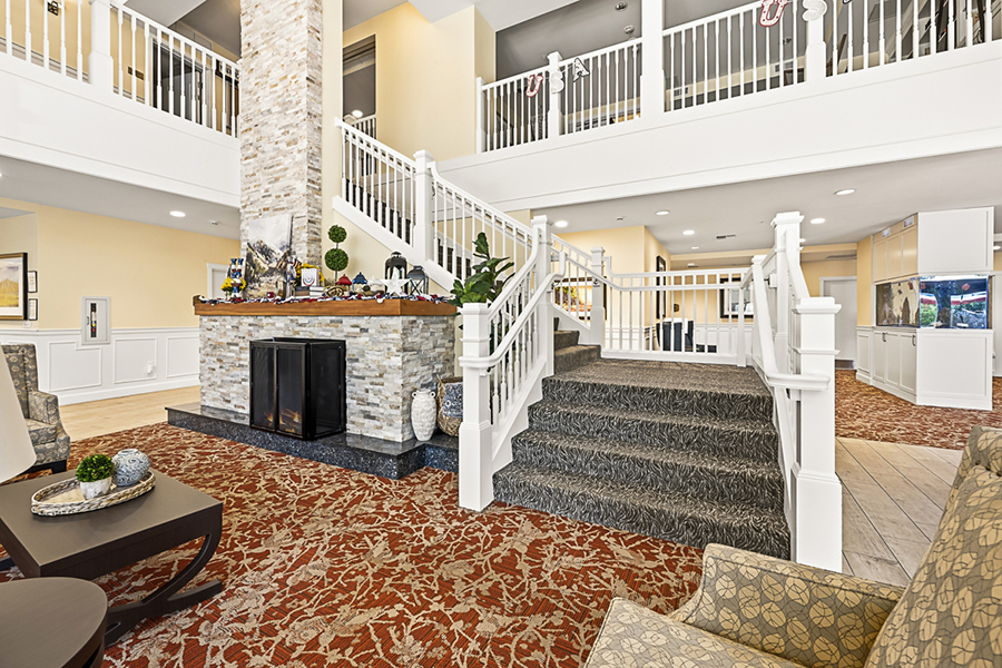 Spacious lobby with stairs, fireplace, and cozy seating.