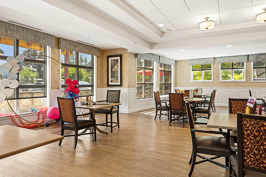 Bright dining area with balloons and tables.