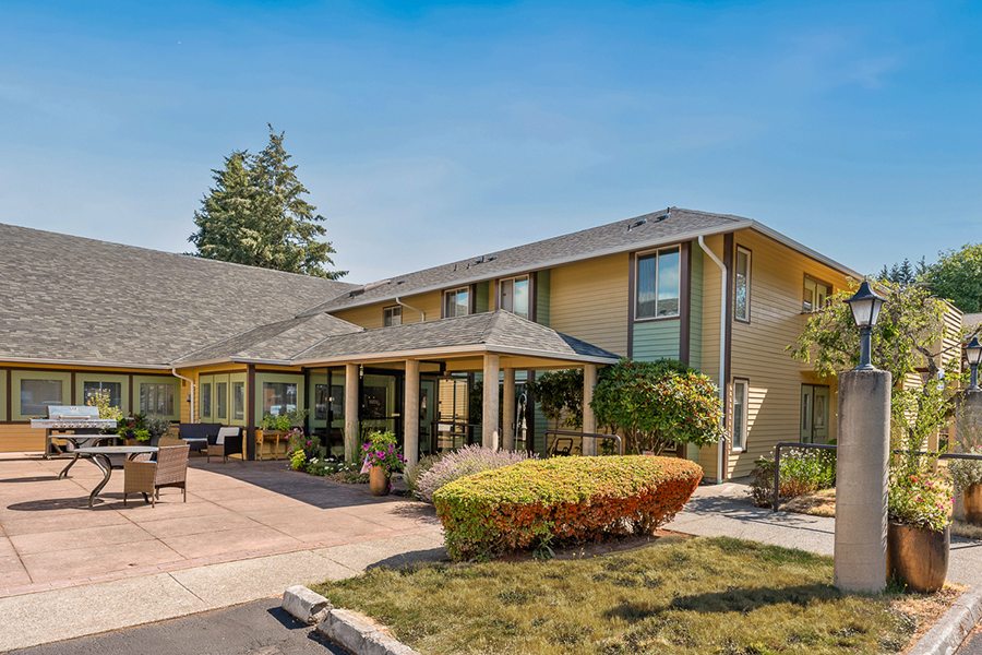 Modern building with landscaped exterior and outdoor seating area.