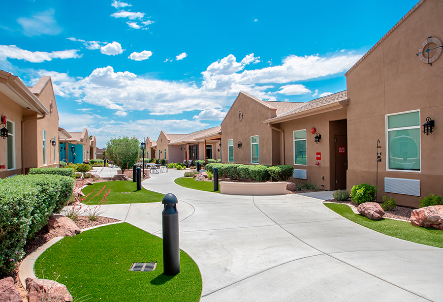 Residential area with gardens and clear blue sky.