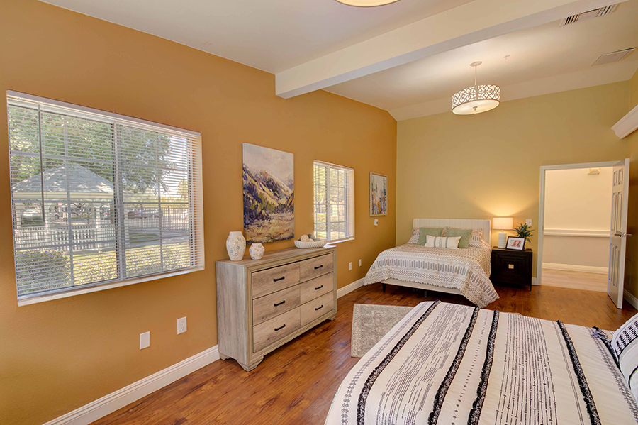 Cozy bedroom with two beds and warm wall colors.