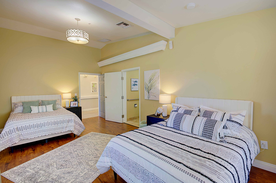 Brightly decorated bedroom with two beds and natural light.