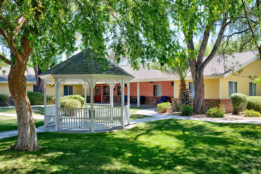A gazebo surrounded by greenery and colorful buildings.