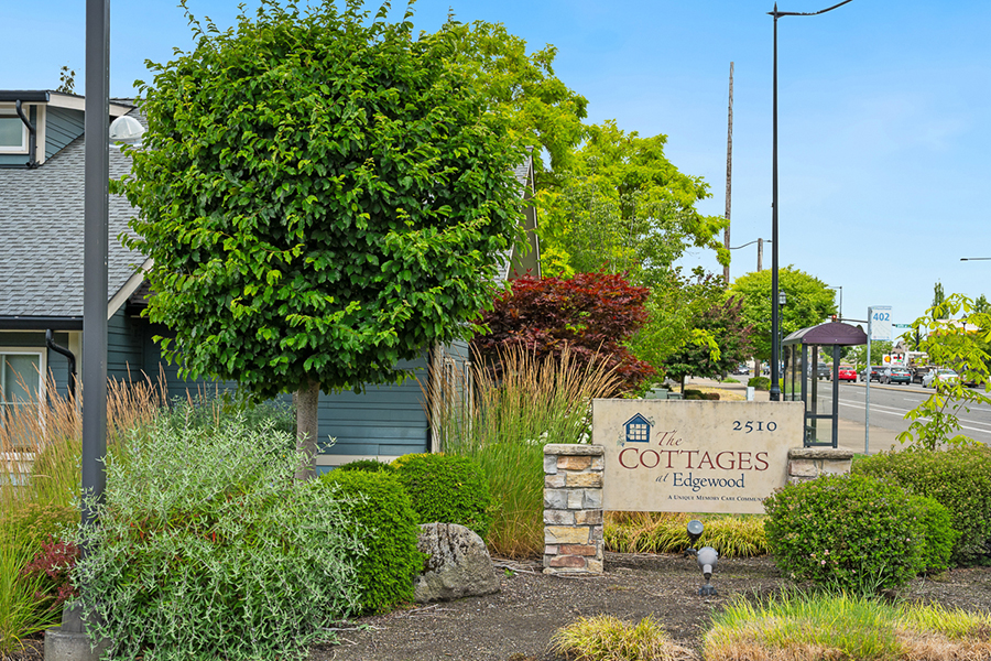 Sign for "The Cottages at Edgewood" surrounded by greenery.