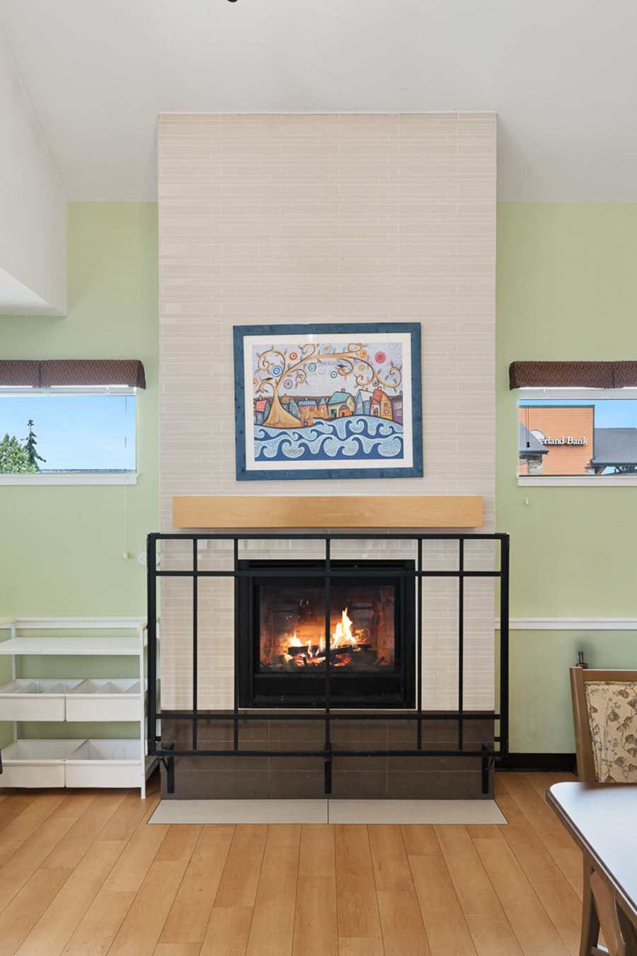Cozy fireplace with artwork in a light-colored room.