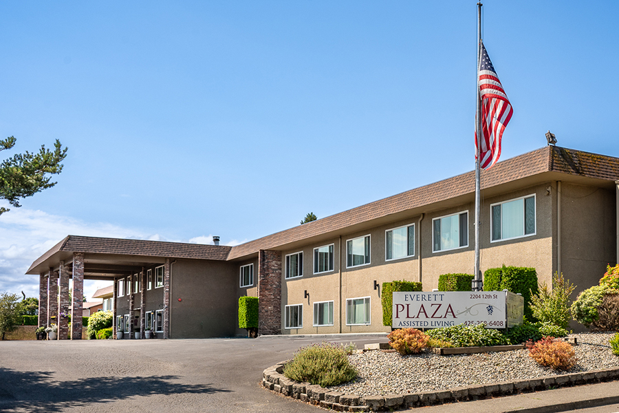 Assisted living facility with American flag and welcoming entrance.