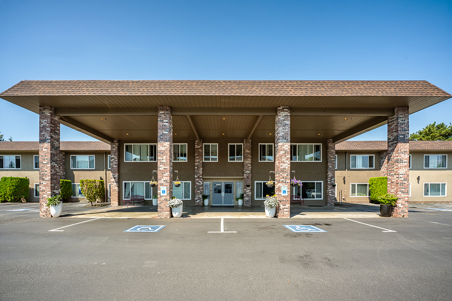 Two-story motel with a covered entrance and landscaped area.