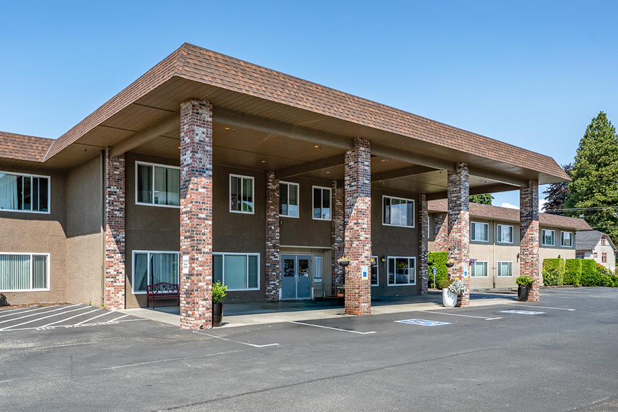 Modern building with brick columns and parking lot.